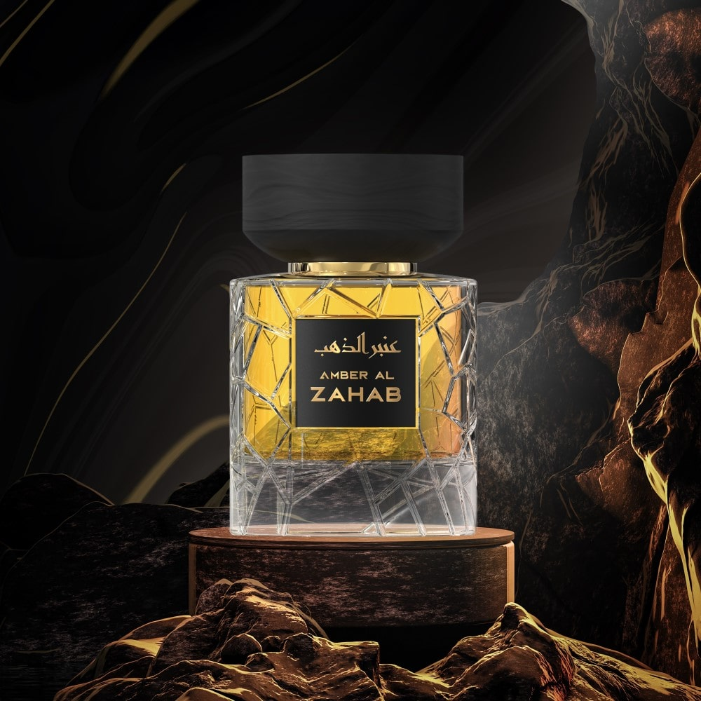 A transparent golden perfume bottle from Nylaa by Savia Exclusive with a black cap on a round brown oak platform